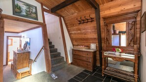 A wooden interior with a staircase, a wooden cabinet, a mirror, and a framed picture on the wall. - Short Drive to the Beach, Hot Tub, Large Deck - All Decked Out (Carnelian Bay)