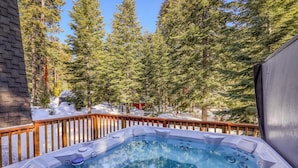 A hot tub with a wooden deck and a snowy forest backdrop. - Short Drive to the Beach, Hot Tub, Large Deck - All Decked Out (Carnelian Bay)