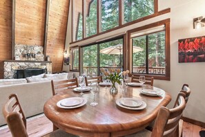 A dining area with a large wooden table set for six, surrounded by chairs. - Short Drive to the Beach, Hot Tub, Large Deck - All Decked Out (Carnelian Bay)
