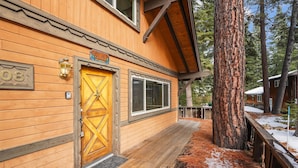 A wooden cabin with a large door, a window, and a sign that reads "Chalet".