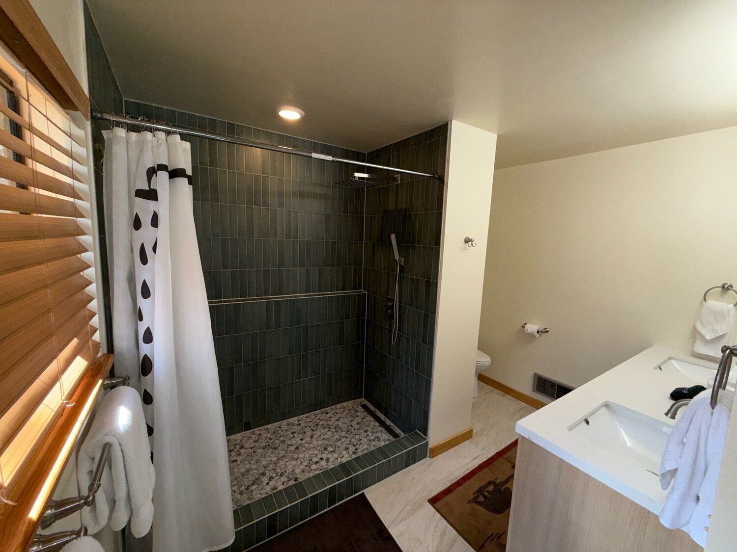 A modern bathroom with a shower, toilet, and sink.