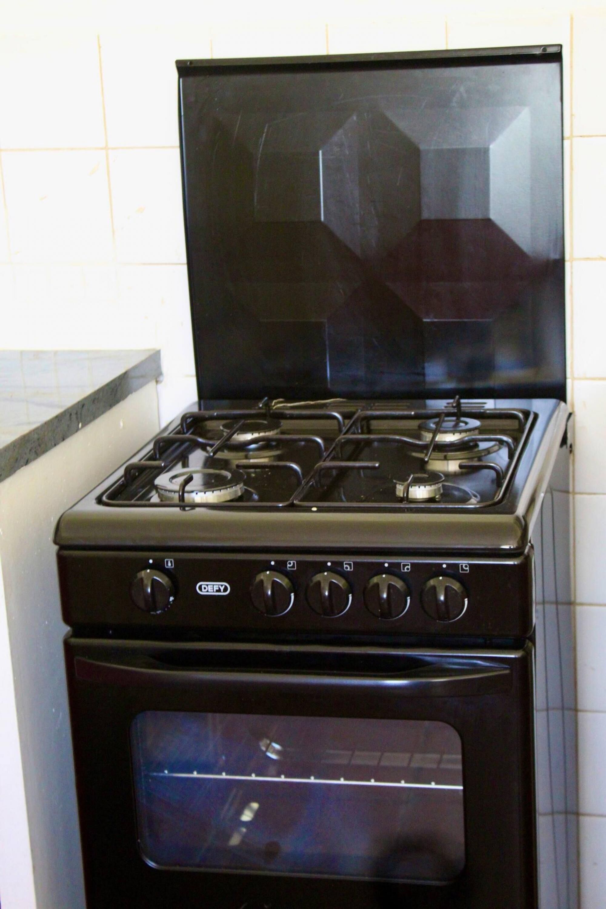 A black stove with four burners and a built-in oven.