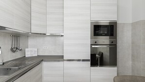 Une cuisine moderne équipée d’appareils électroménagers en acier inoxydable, d’un four encastré et d’un four à micro-ondes.