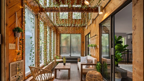 Une terrasse accueillante, avec des meubles en osier, une table en bois et des plantes en pot.