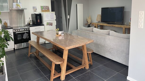 Una cocina moderna con comedor, un sofá y un televisor.