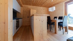 Una cucina moderna con pareti in legno e un'area pranzo con tavolo e sedie.