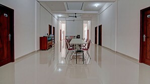 A spacious hallway with a dining area featuring a long table and chairs, a ceiling fan, and a polished floor. - Hotel O Penginapan Sarinah SyariahNearRM Beringin Indah (Pangkalan Kuras)