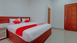 A neatly made bed with white and red bedding, a wooden headboard, and a wooden door in a clean, white-walled room. - Hotel O Penginapan Sarinah SyariahNearRM Beringin Indah (Pangkalan Kuras)