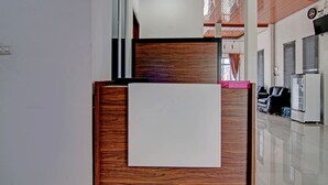 A modern interior with a wooden reception desk, a whiteboard, and a clean, polished floor. - Hotel O Penginapan Sarinah SyariahNearRM Beringin Indah (Pangkalan Kuras)