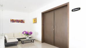 A modern living room with a sofa, coffee table, and artwork on the wall. - Hotel Cinco Monteria (Montería)
