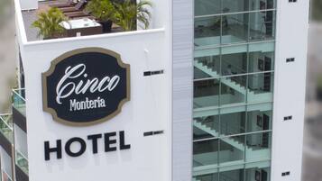 Ein modernes Hotel mit einem gut sichtbaren Schild, auf dem "Cinco Montería HOTEL" steht.