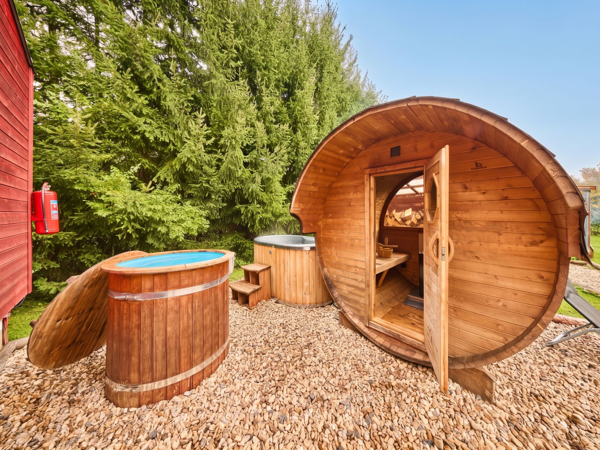 Un sauna avec une structure extérieure en bois, un bain à remous et un espace de stockage pour le bois de chauffage.