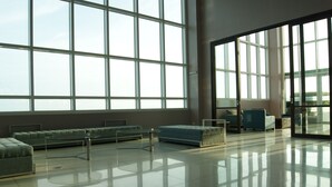 A spacious lobby with large windows, a seating area with sofas and armchairs, and a polished floor. - The Beacon Makati by mvmtransient (Makati)