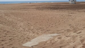 A beach with a lifeguard tower and footprints in the sand. - Joli Mobilhome Climatisé, 4 Pers. Campingla Falaise Plage à 300m, Piscine (Narbonne)