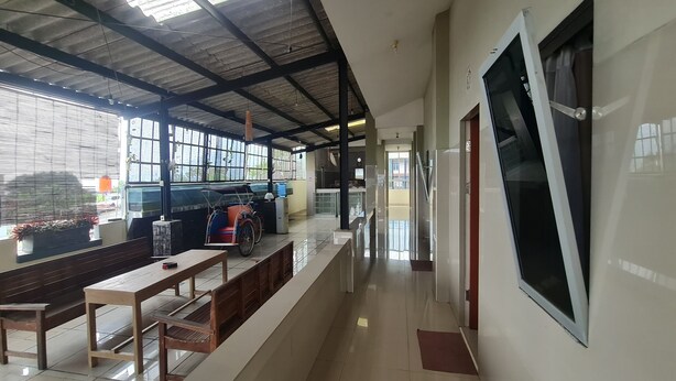 A spacious indoor area with a high ceiling, a long bench, and a table.