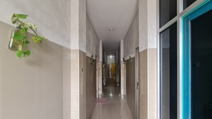A corridor with tiled walls and a door on the right.