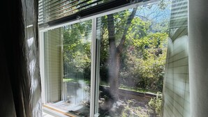 A window with a view of a garden and trees. - SE Boise Condo • Pool • Parking • Hot Tub+ 2 Private Master Suites (Boise)