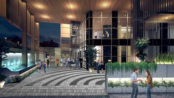A modern building with a glass facade, a wooden ceiling, and a landscaped area with plants.