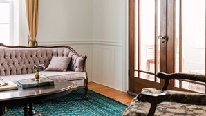 A living room with a tufted sofa, a coffee table, and a patterned rug. - Little Louis - A Princely Take on a County Getaway (Prince Edward)