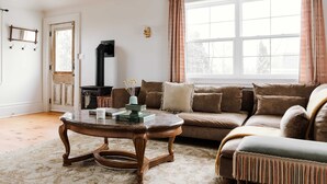 A cozy living room with a sofa, a coffee table, and a fireplace. - Little Louis - A Princely Take on a County Getaway (Prince Edward)