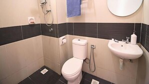Un baño pequeño con inodoro, lavamanos, espejo y ducha.