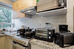 A kitchen with a stove, oven, microwave, toaster, and coffee maker. - Capitalia - Best Choice  in Anzures (Ciudad de México)