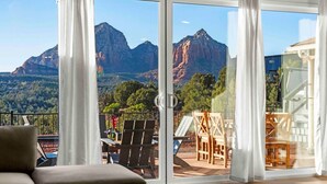 Habitación con un gran ventanal corredera que ofrece vistas a la montaña.