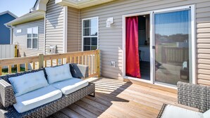 A covered deck with a wicker sofa and a wooden railing. - Cape Charles Home: 4 Mi to Kiptopeke State Park! (Cape Charles)
