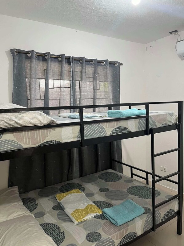 Habitación con literas, ventana y cortinas.