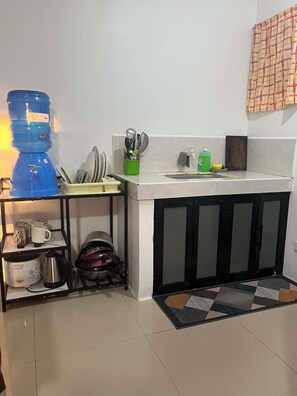 Una cocina con dispensador de agua, cafetera y lavabo.