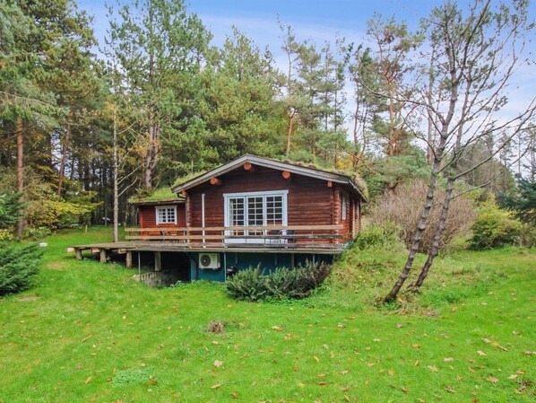 A wooden cabin with a porch, surrounded by a forest. - "Peadda" - 900m from the sea by Interhome (Hjørring)