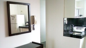 A kitchen with a black countertop, a white sink, and a microwave. -  Aparts4Days 1 Bedroom Apartment San Isidro Olivar (Lima)