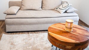 A living room with a sofa, a round wooden coffee table, and a rug. - Stilvolles Gemütliches Modernes Haus 4-7 Person - Netflix - Wlan (Passau)
