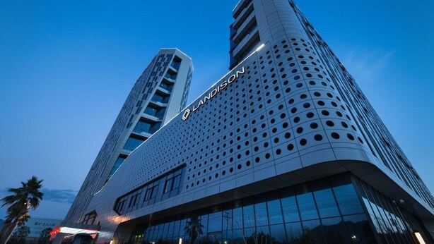 En moderne hotelbygning med en markant facade med perforeringer, hvor navnet "LADISON" er synligt.