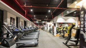 Et fitnesscenter med løbebånd og træningsudstyr.