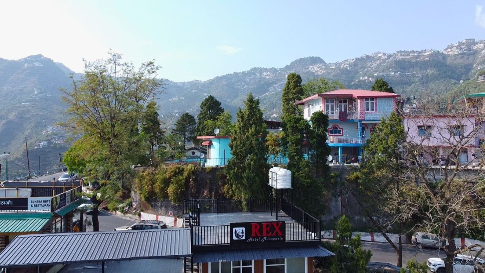 Hotel REX, con vistas a montañas al fondo.