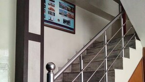 A staircase with a metal handrail and a wooden wall panel. - Hotel Shyam Palace (New Delhi)