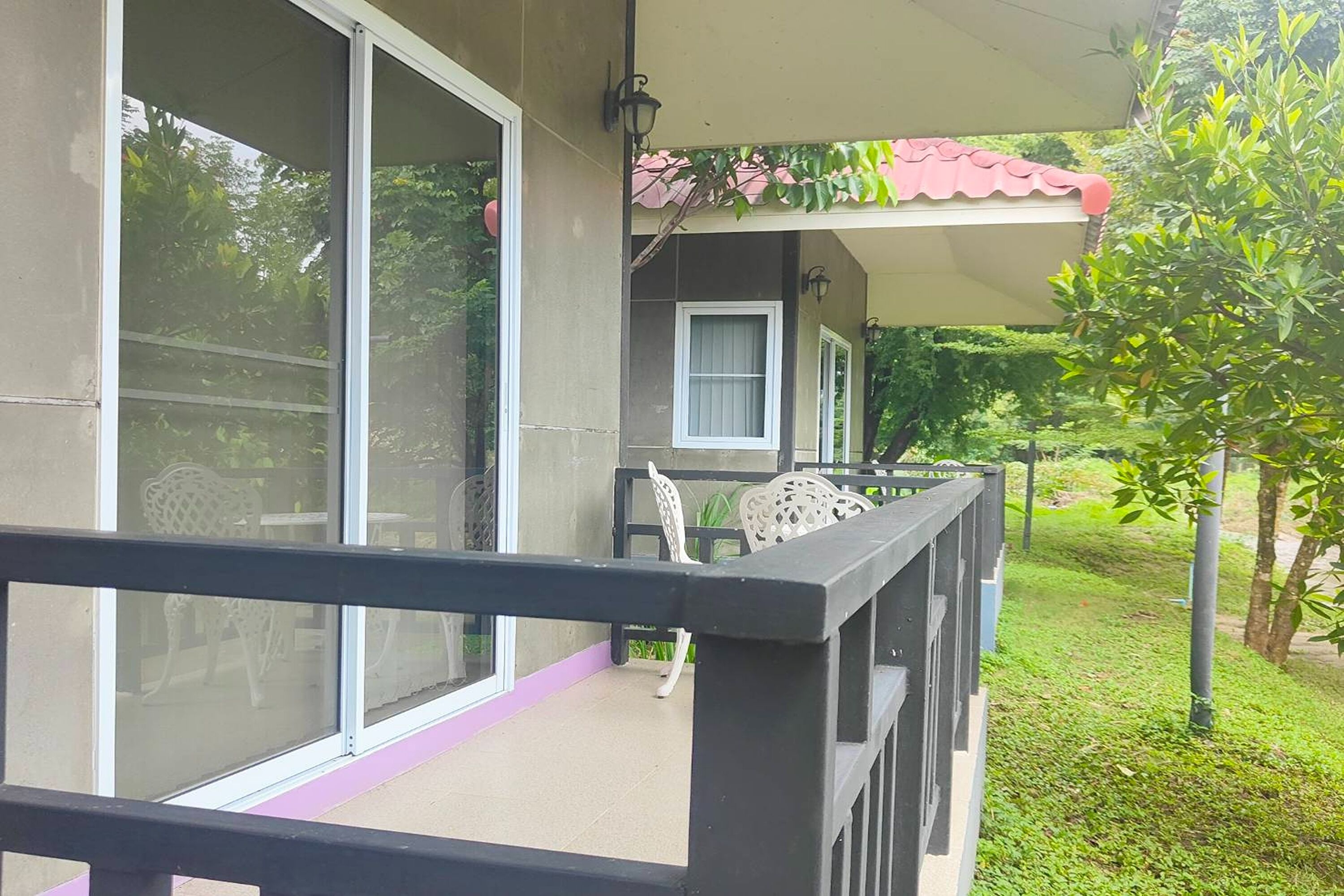 A balcony with a glass door, a small table, and chairs.