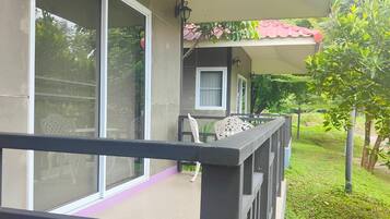 A balcony with a glass door, a small table, and chairs.