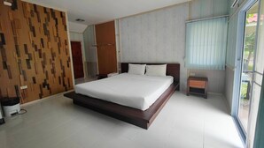 A modern bedroom with a large bed, wooden panel wall, and a small bedside table. - The Creek Resort (Doi Tao)