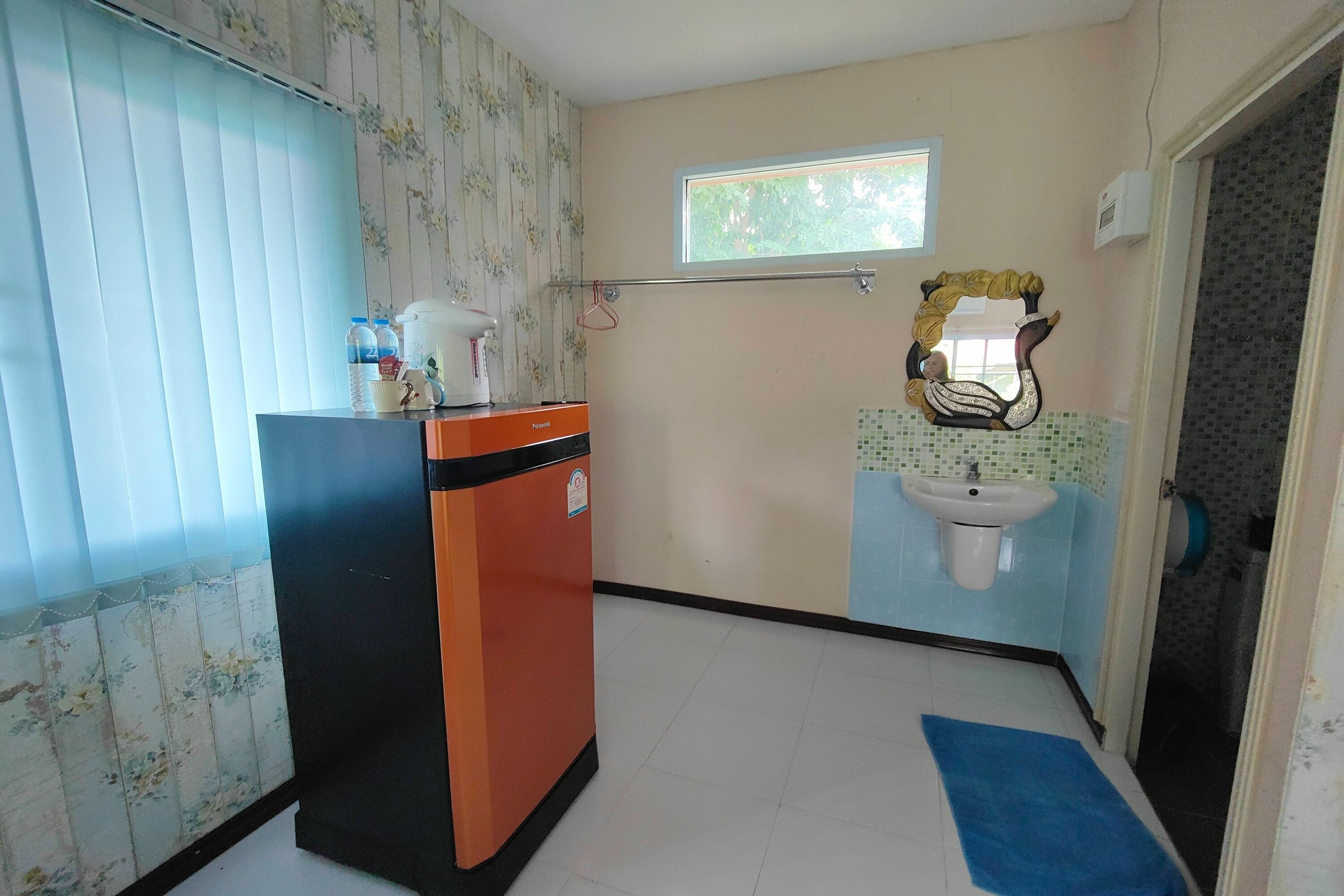 Un baño con lavamanos, espejo y ventana.