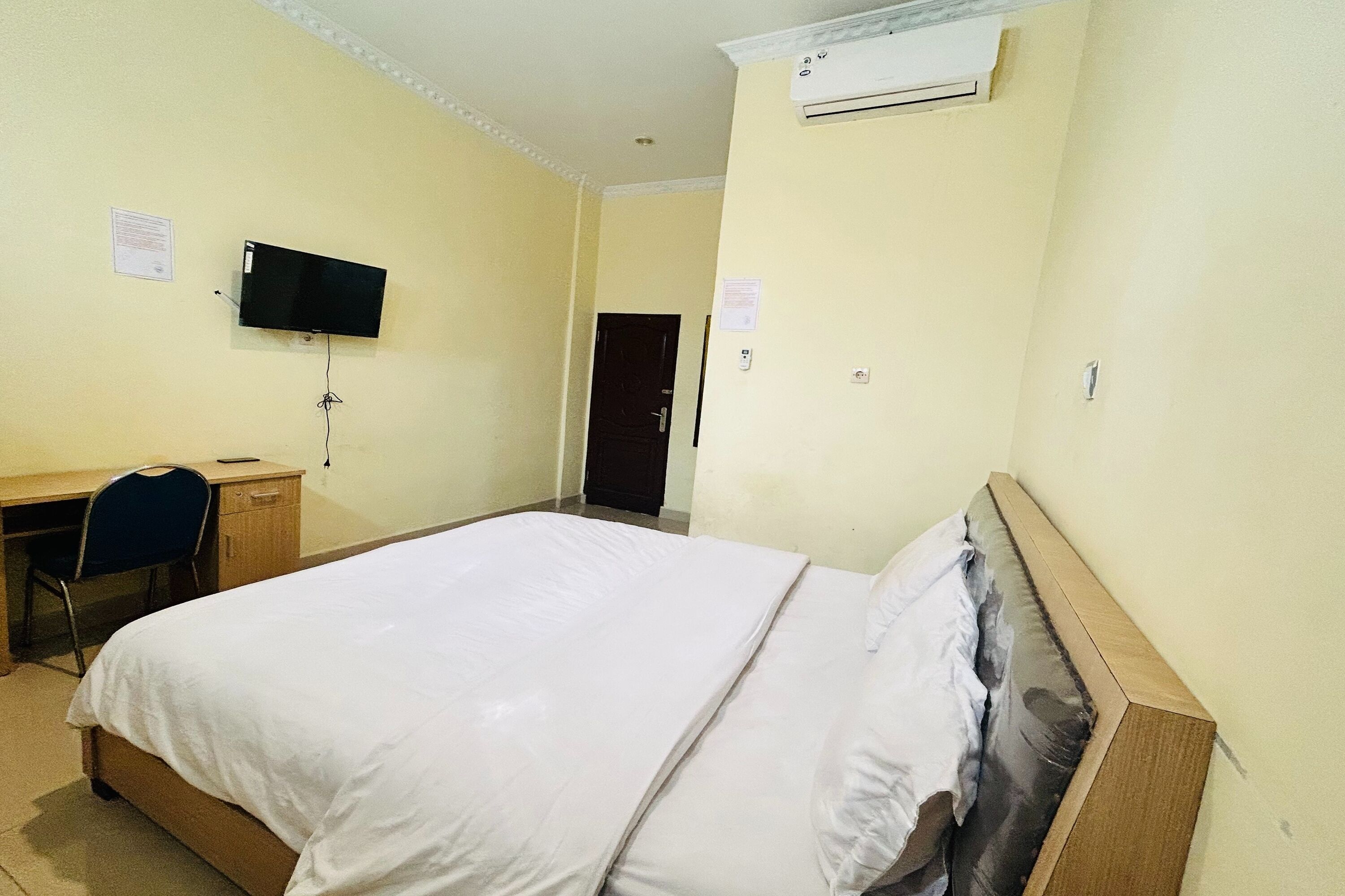 Une chambre d’hôtel équipée d’un lit, d’un bureau, d’une chaise, d’une télévision et d’un appareil de climatisation.