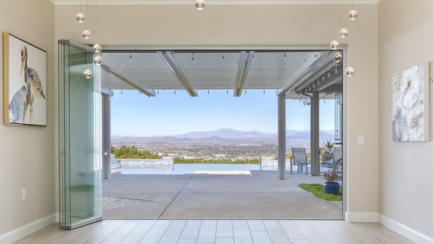 Ein modernes Interieur mit Glastür und Zugang zu einer Terrasse mit Blick auf die Stadt.