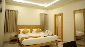 A hotel room with a bed, nightstand, and a mirror. - IRIS HOTEL TIRUPATI (Tirupati)