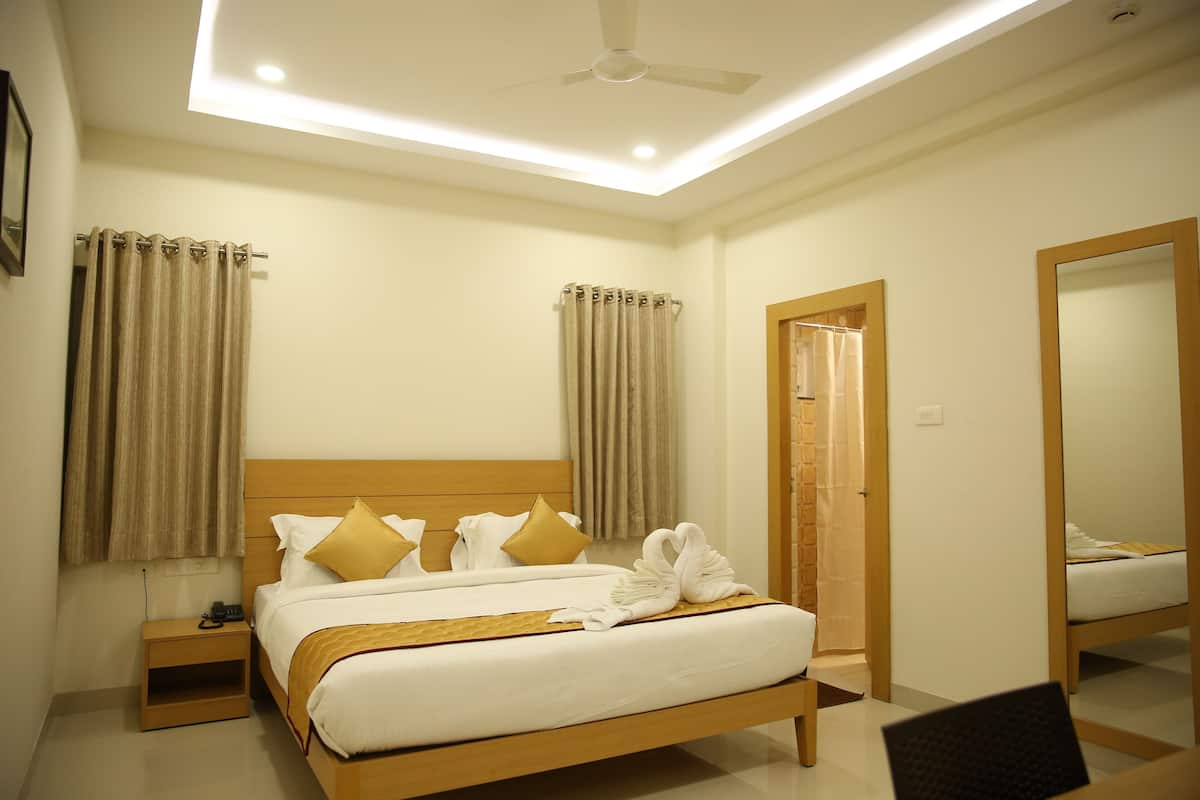 A hotel room with a bed, nightstand, and a mirror.