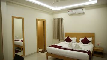 A neatly arranged hotel room with a bed, a bedside table, a mirror, and a ceiling fan.