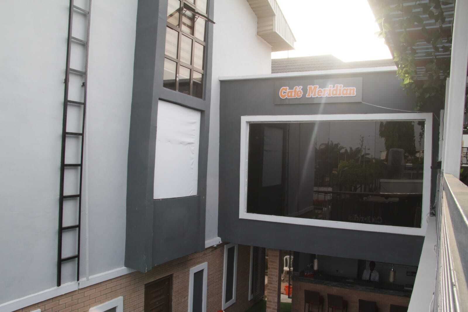 Ein Gebäude mit einem Schild, auf dem "Café Meridiani" steht, über einem großen Fenster.