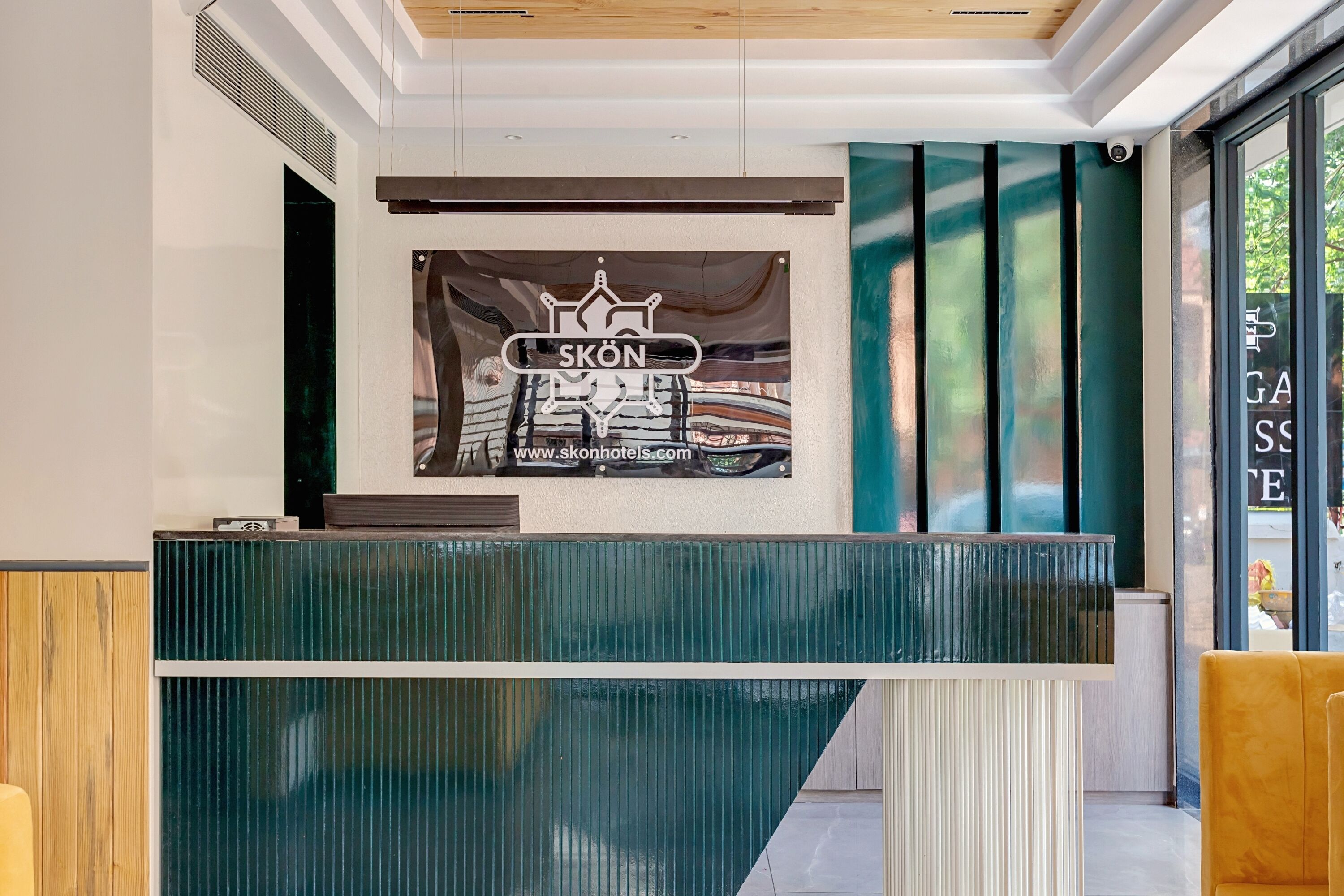 A reception desk with a logo and website for 'SKON Hotels'.