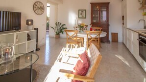 A modern kitchen with a dining area, a television, and a clock on the wall. - Vacation home Randi by Interhome (Anzio)