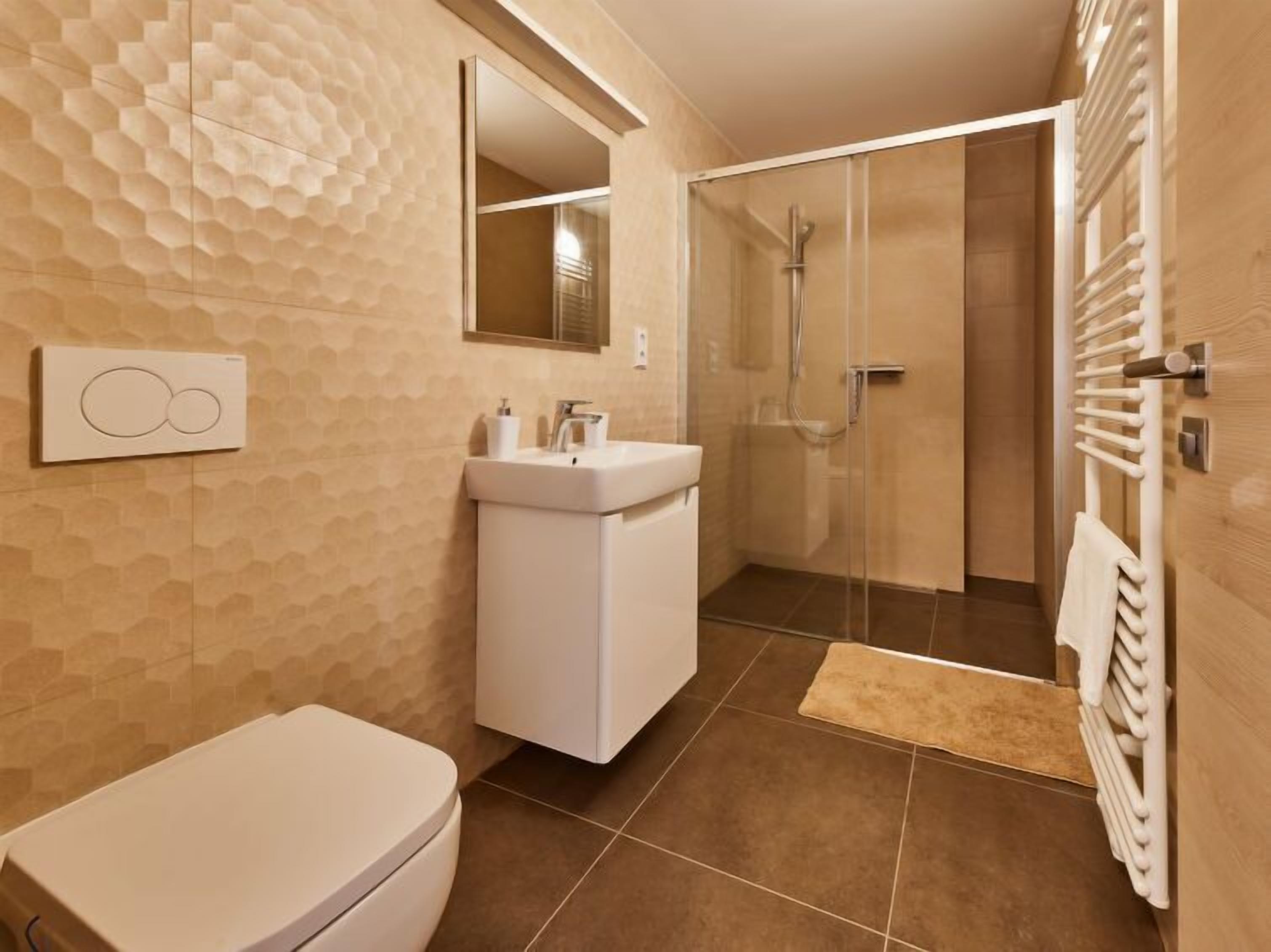 Une salle de bain moderne équipée de toilettes, d’un lavabo et d’une douche.
